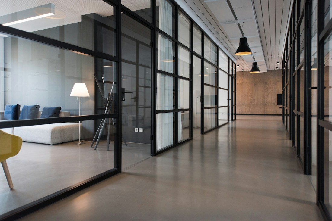 Bright shared office with glass partitions and worktables.